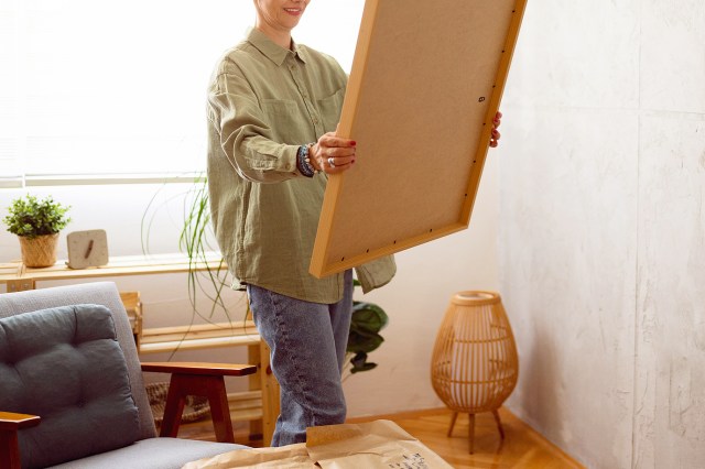 An image of a woman holding a large frame