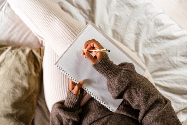 An image of a person writing in a notebook