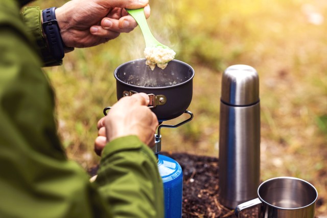 An image of a person with an outdoor cooking setup