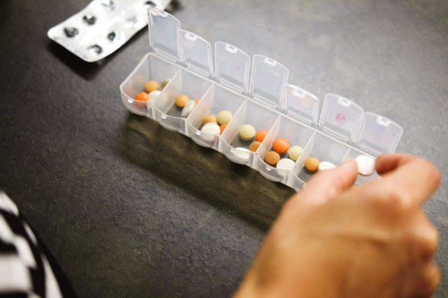 An image of a person putting pills into a pill box