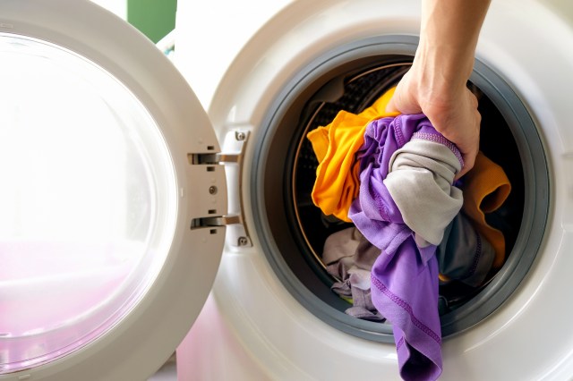 An image of a person taking clothes out of the dryer