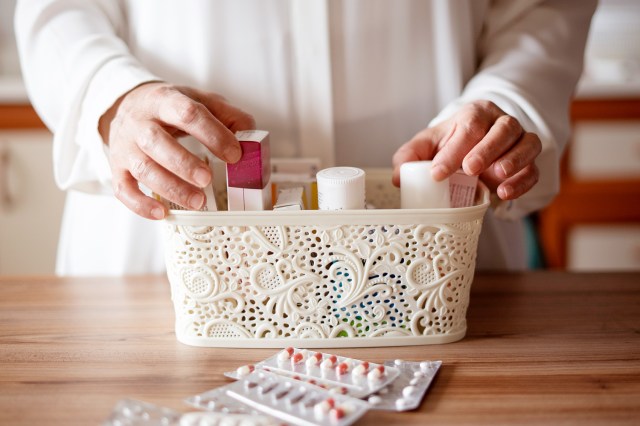 An image of a person putting medicine into a small basket