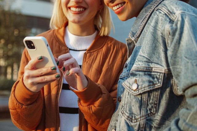 An image of two women looking at an iPhone