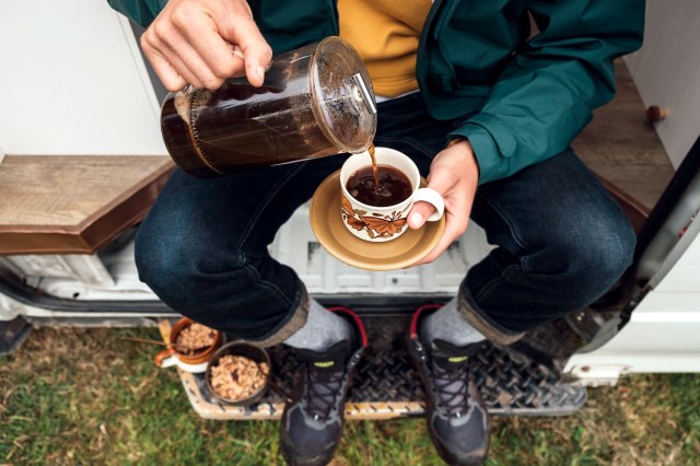 An image of a man pouring coffee from a French press