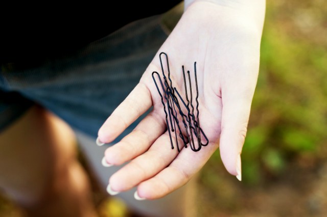 An image of bobby pins in the palm of someone's hand