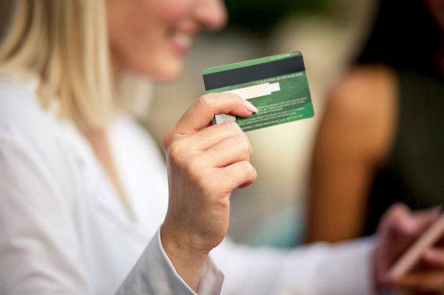 An image of a woman holding a credit card