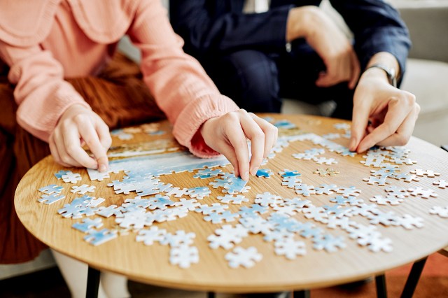 An image of two people doing a jigsaw puzzle