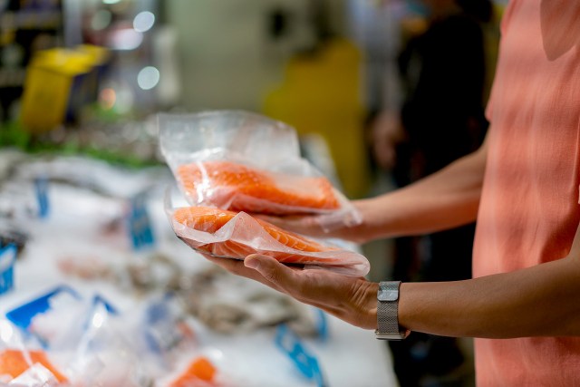An image of person two package of fish in the grocery store