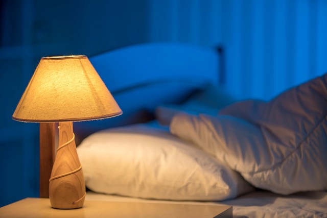 An image of a nightstand with a light on