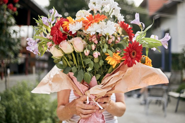 An image of a woman holding a large bouquet of flowers