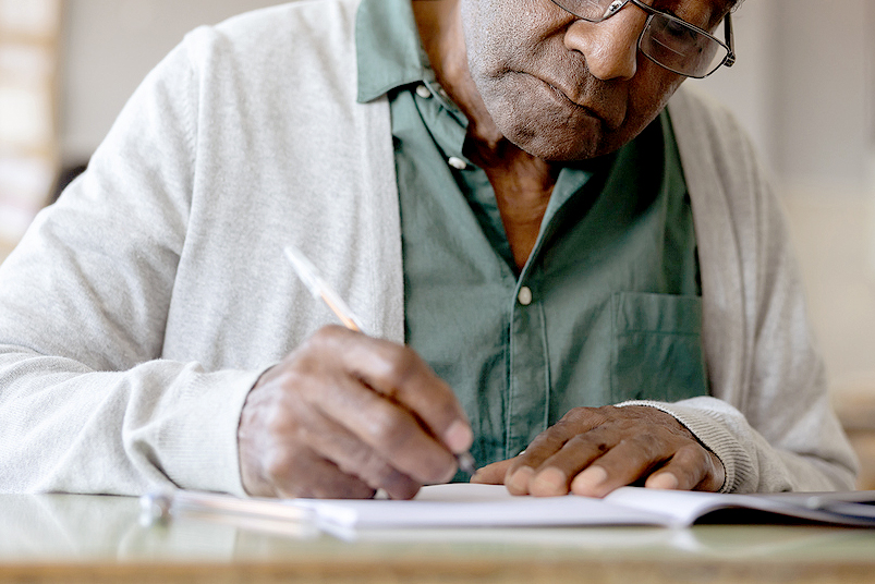 An image of a man writing in a notebook