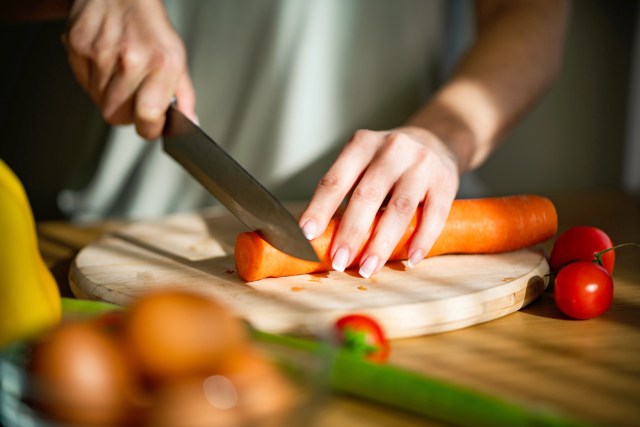 An image of a person cutting a carrot