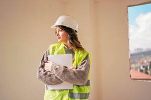 Woman with construction vest and hat on in room