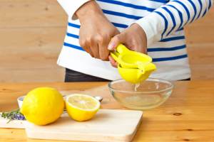 Person using a citrus juicer to juice a lemon