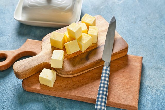 Butter on a cutting board next to a knife