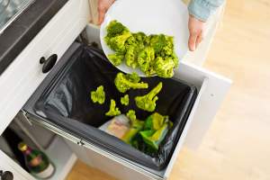 Broccoli being thrown in the trash