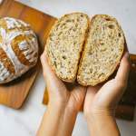 Person holding a loaf of bread that's been cut in half