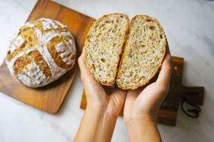 Person holding a loaf of bread that's been cut in half