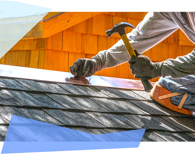 Person hammering a nail on roof 