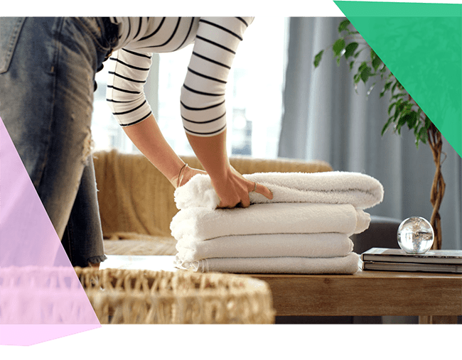 Person folding and stacking white towels 