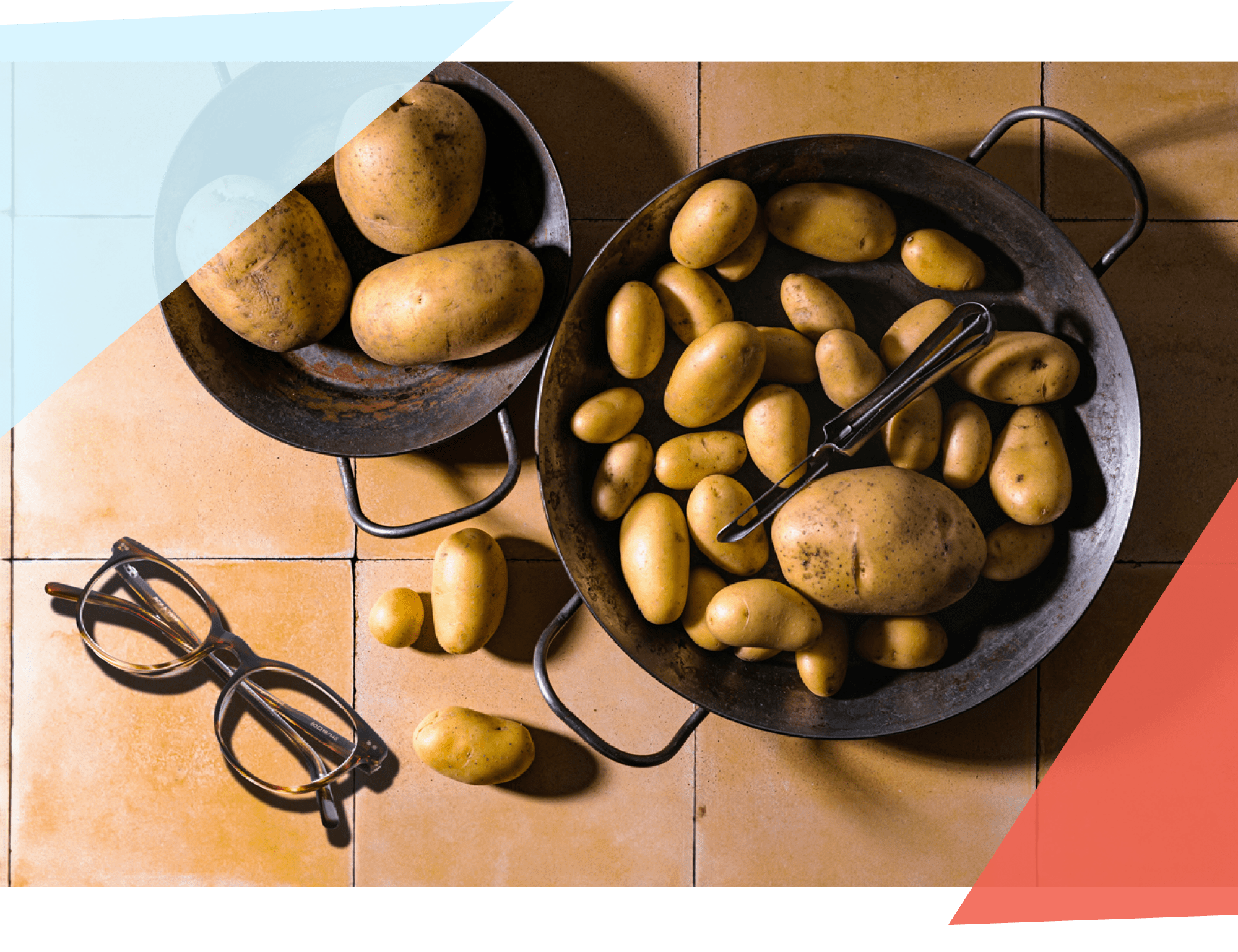 Two pans of potatoes next to a pair of glasses 