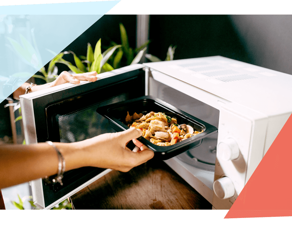 Person putting a tray of food in the microwave 