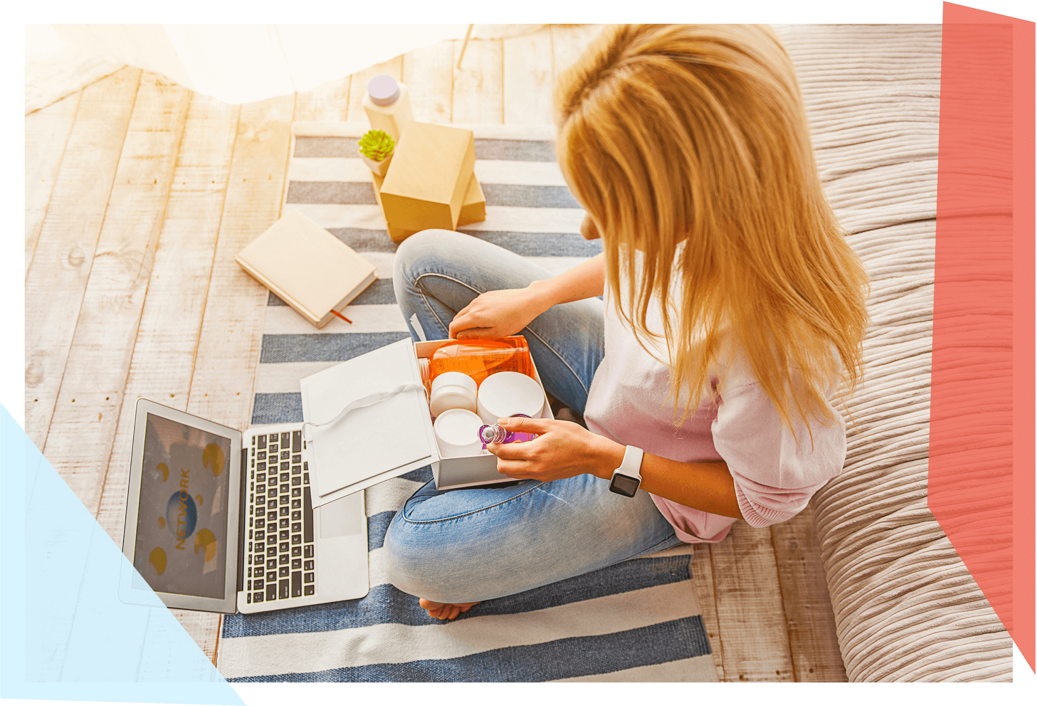 Woman sitting and looking through a box of products in front of computer 