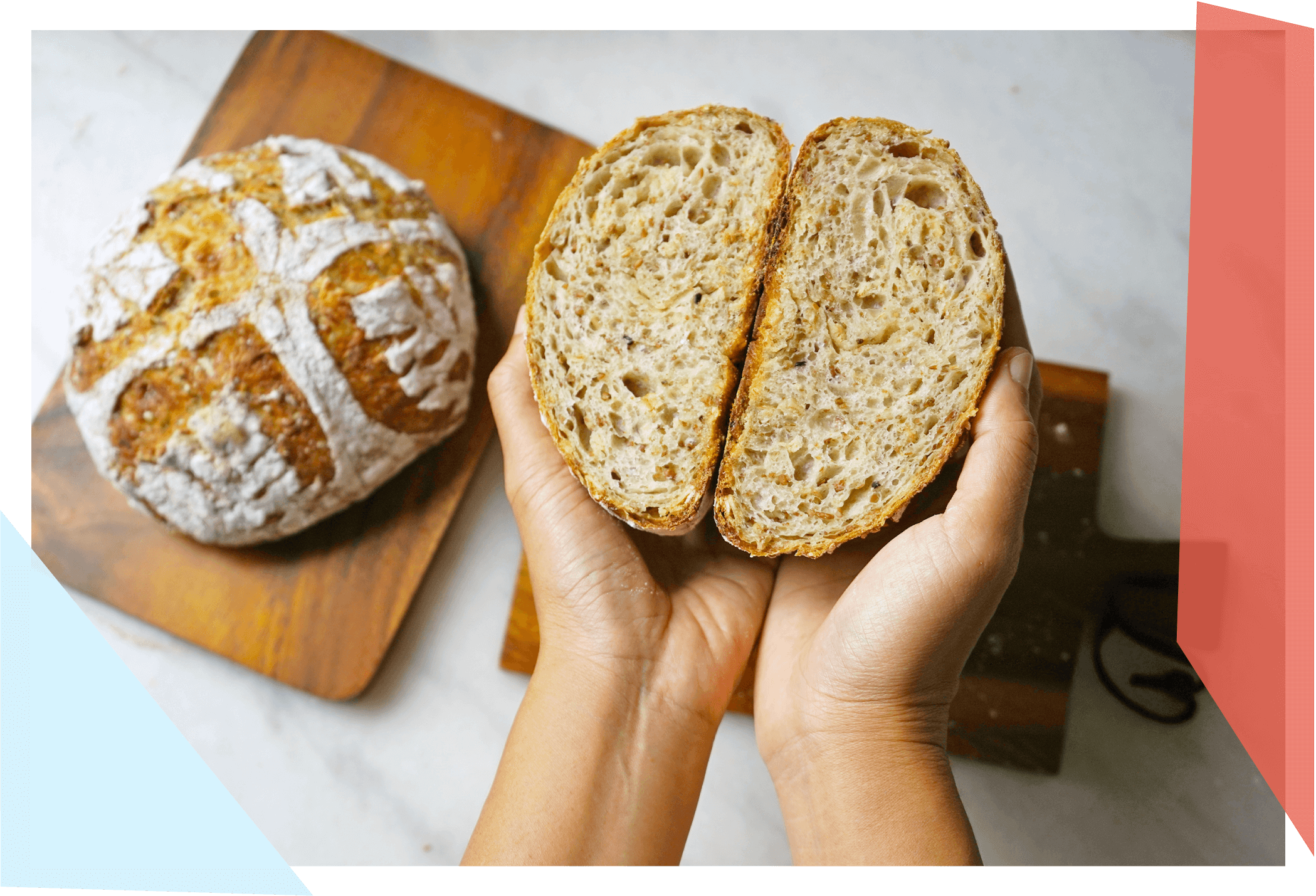 Person holding a loaf of bread that's been cut in half 