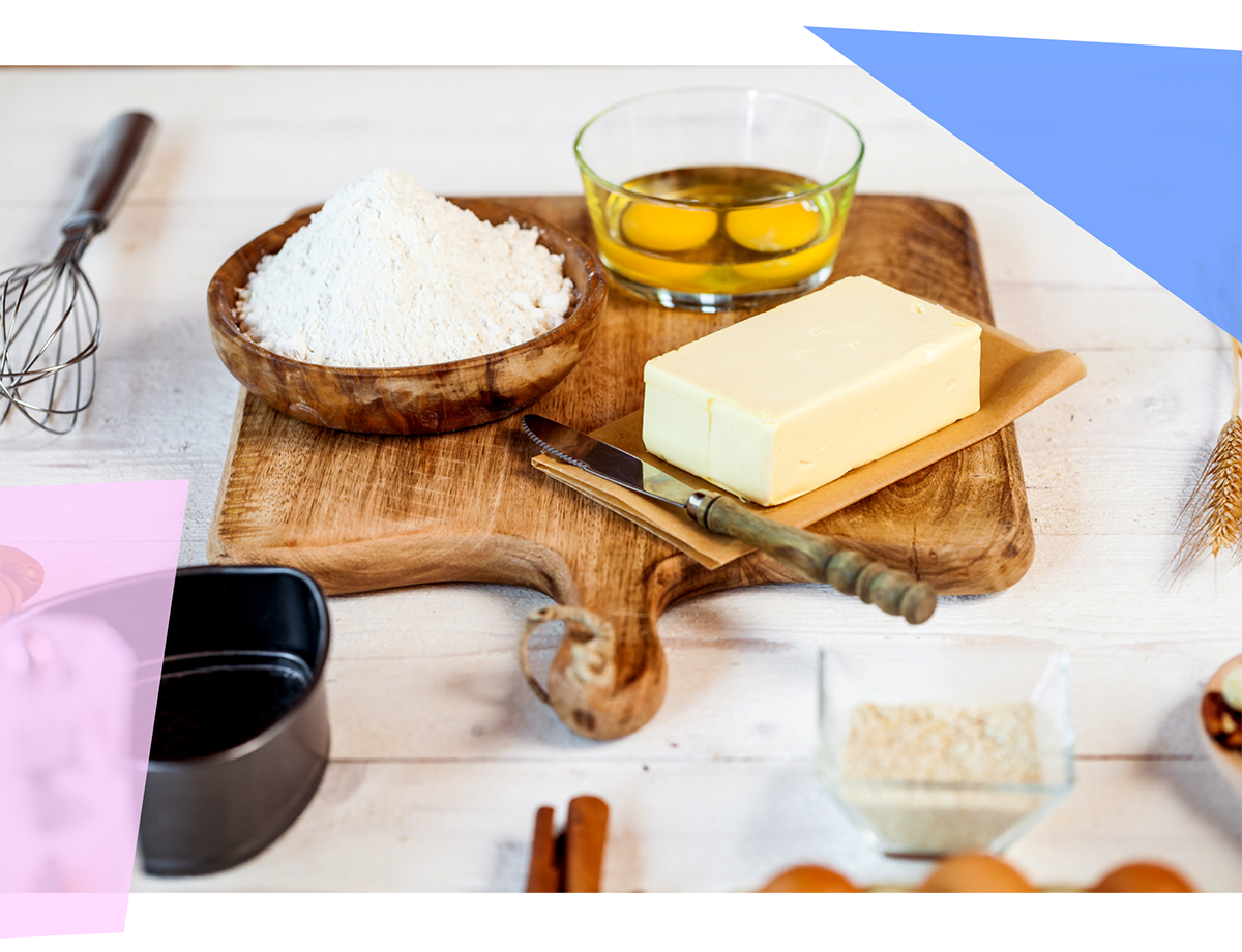 Cutting board with butter, eggs, and bowl of baking powder 