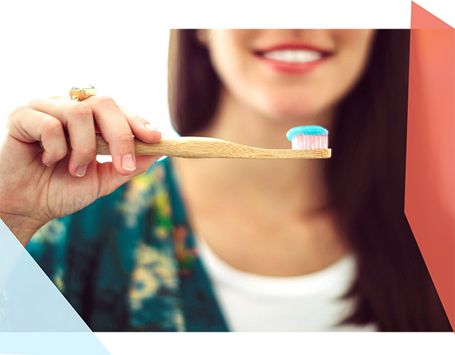 Woman holding a toothbrush with toothpaste on it. 