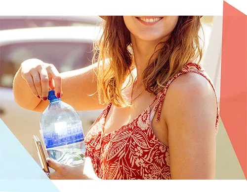 Woman smiling while opening a plastic water bottle 