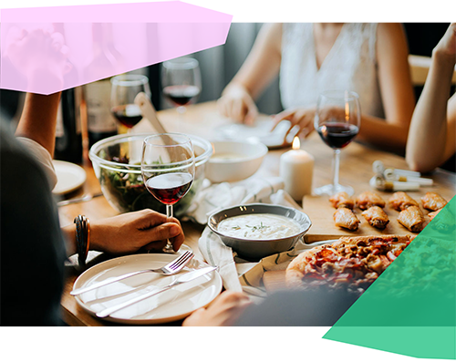 People sitting around a dinner table with food and drinks 