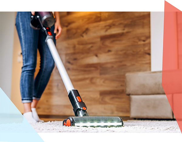 Person vacuuming a carpet with a cordless stick vacuum 