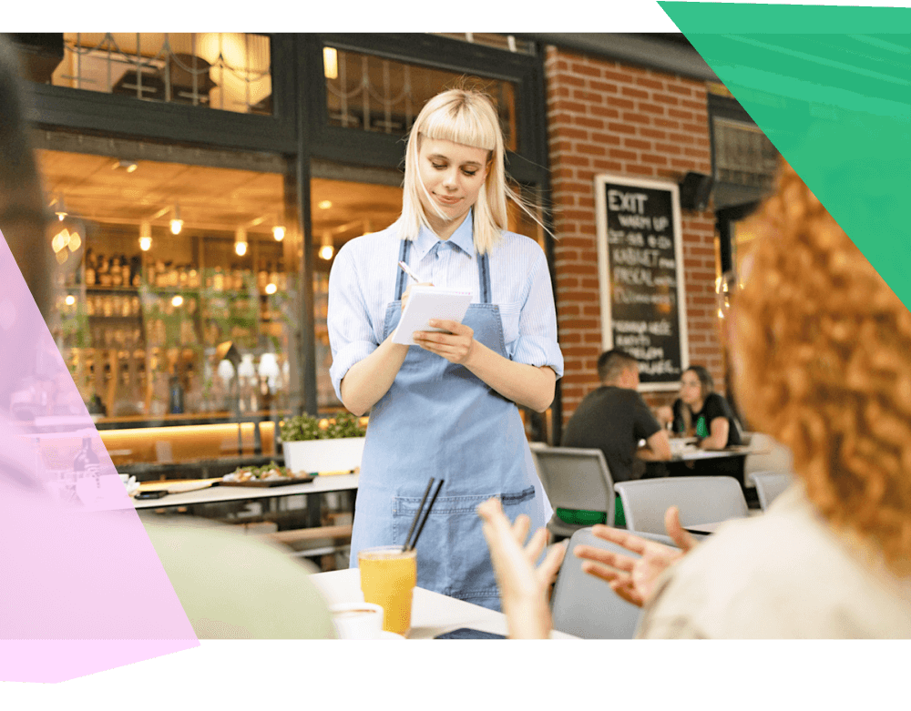 Waiter taking an order at a table on a notepad. 