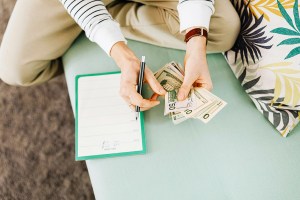 Person Counting Money while budgeting in planner