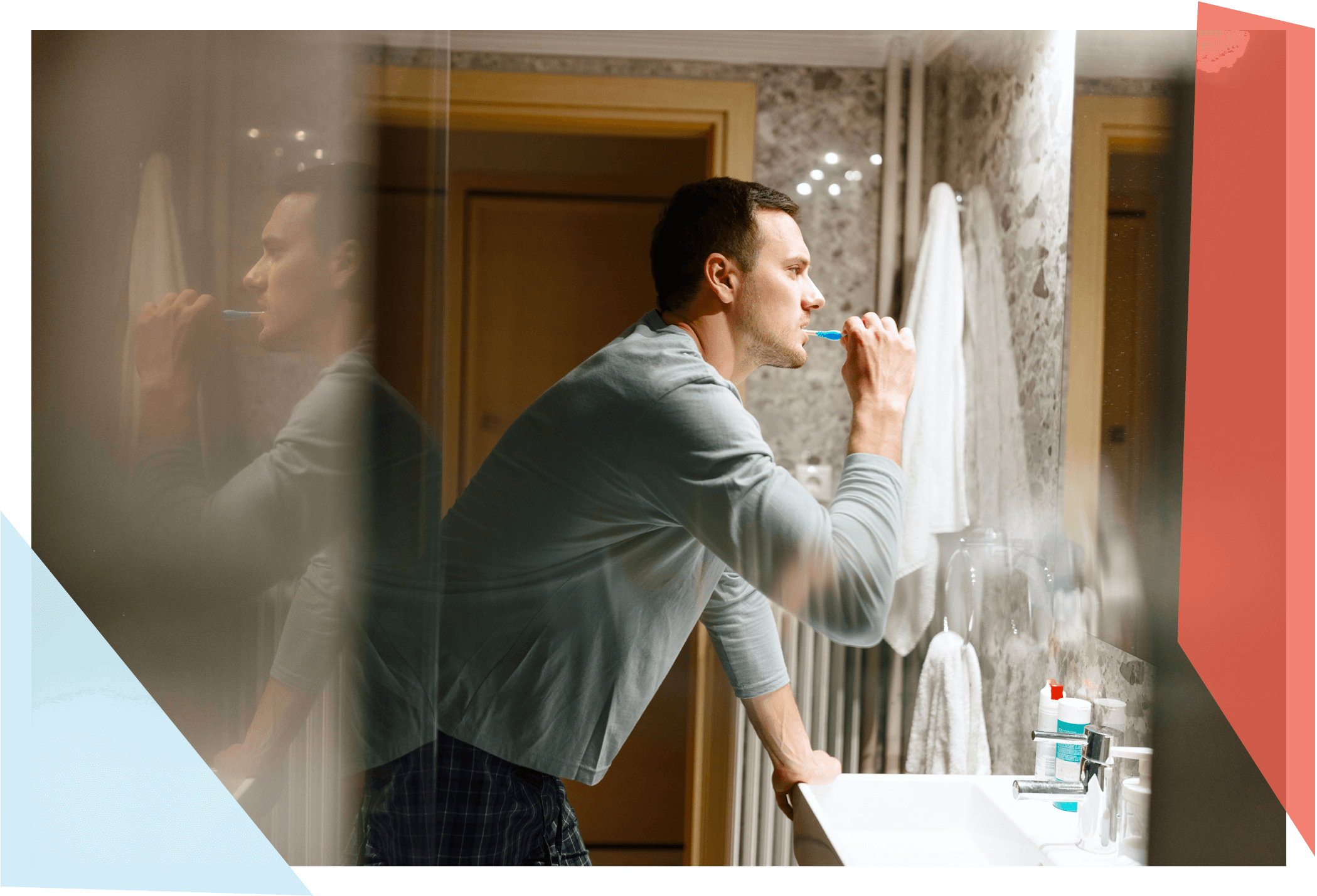 Man standing before bathroom mirror, brushing his teeth 