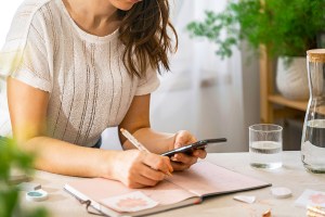 Woman writing in weekly planner