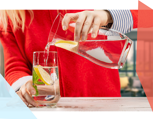 Woman pouring water from a jug into a glass. 