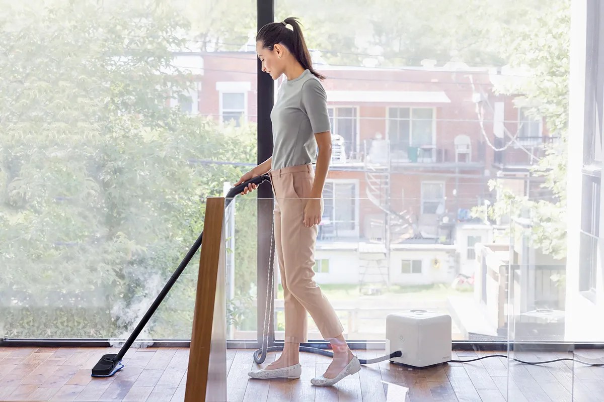 Woman steam cleaning the floor 