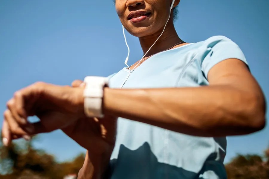 Woman working out and looking at her watch 