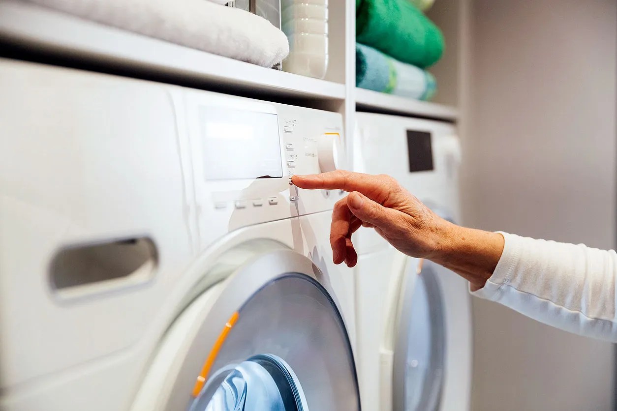 Person turning on washing machine 