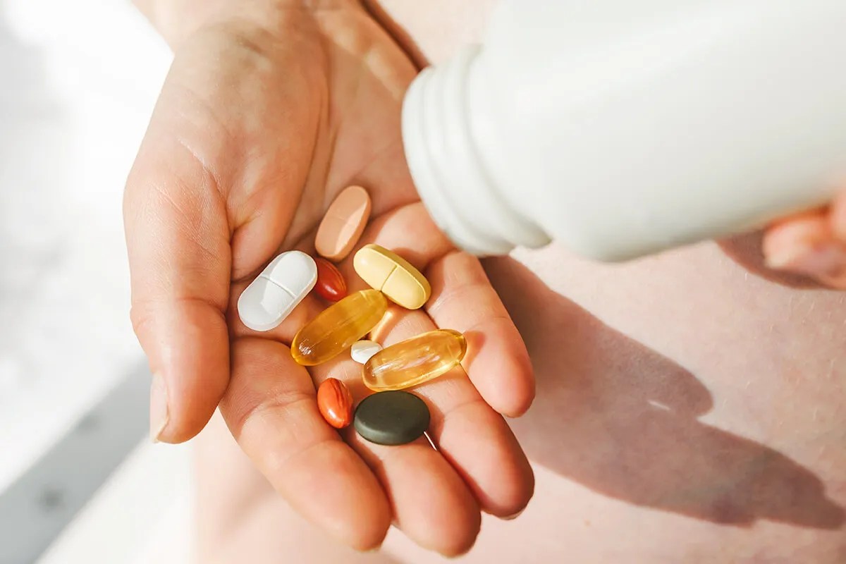 Person pouring vitamins into their palm 