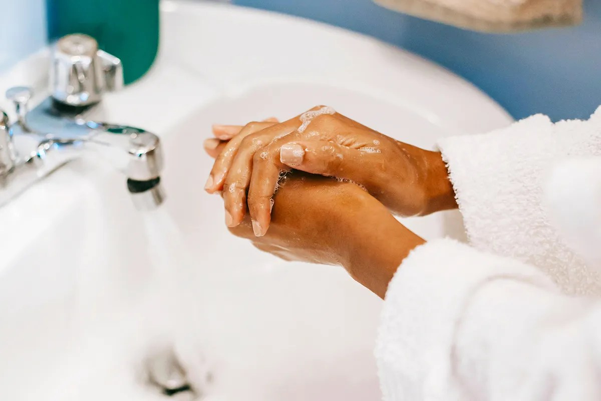 Person washing their hands in the sink. 