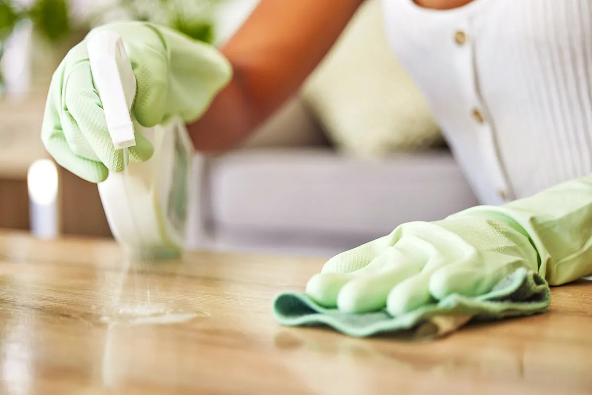 Person cleaning countertops with spray cleaner