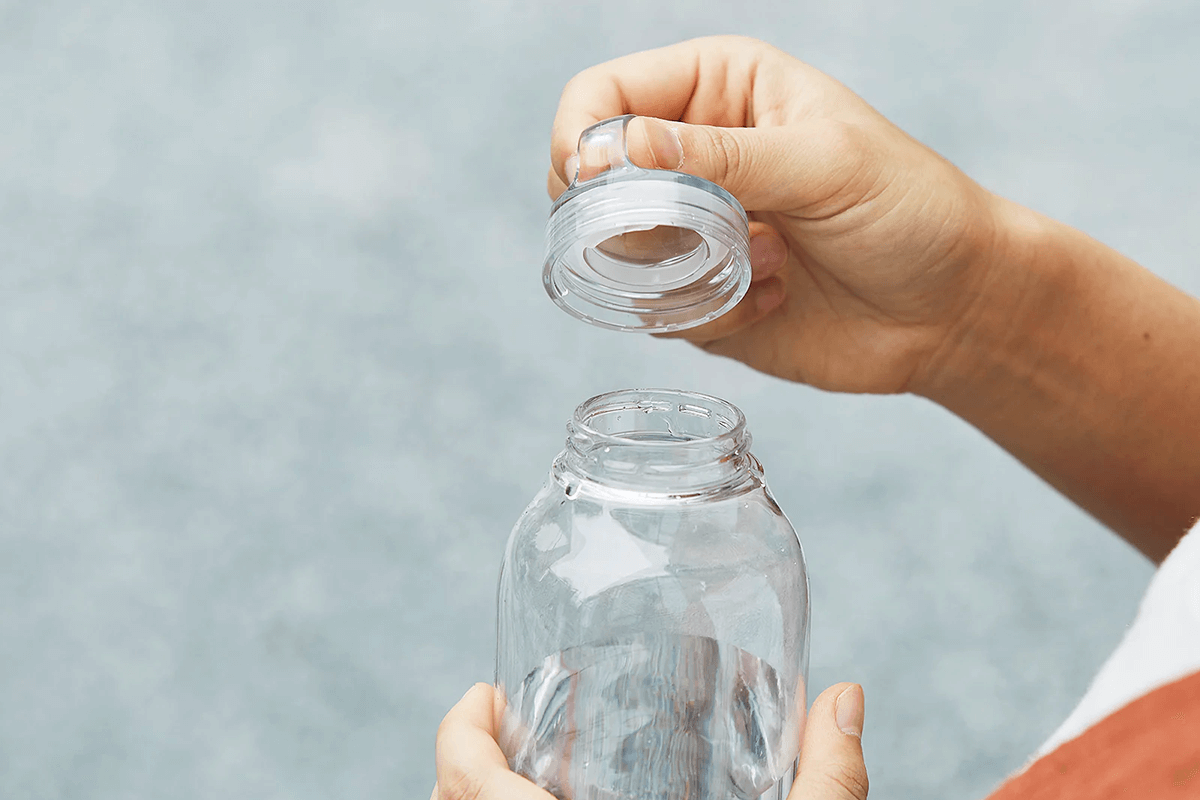 Someone taking the lid off a water bottle 