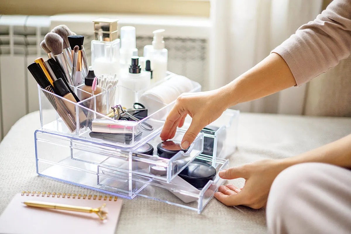 Person putting makeup in organizer