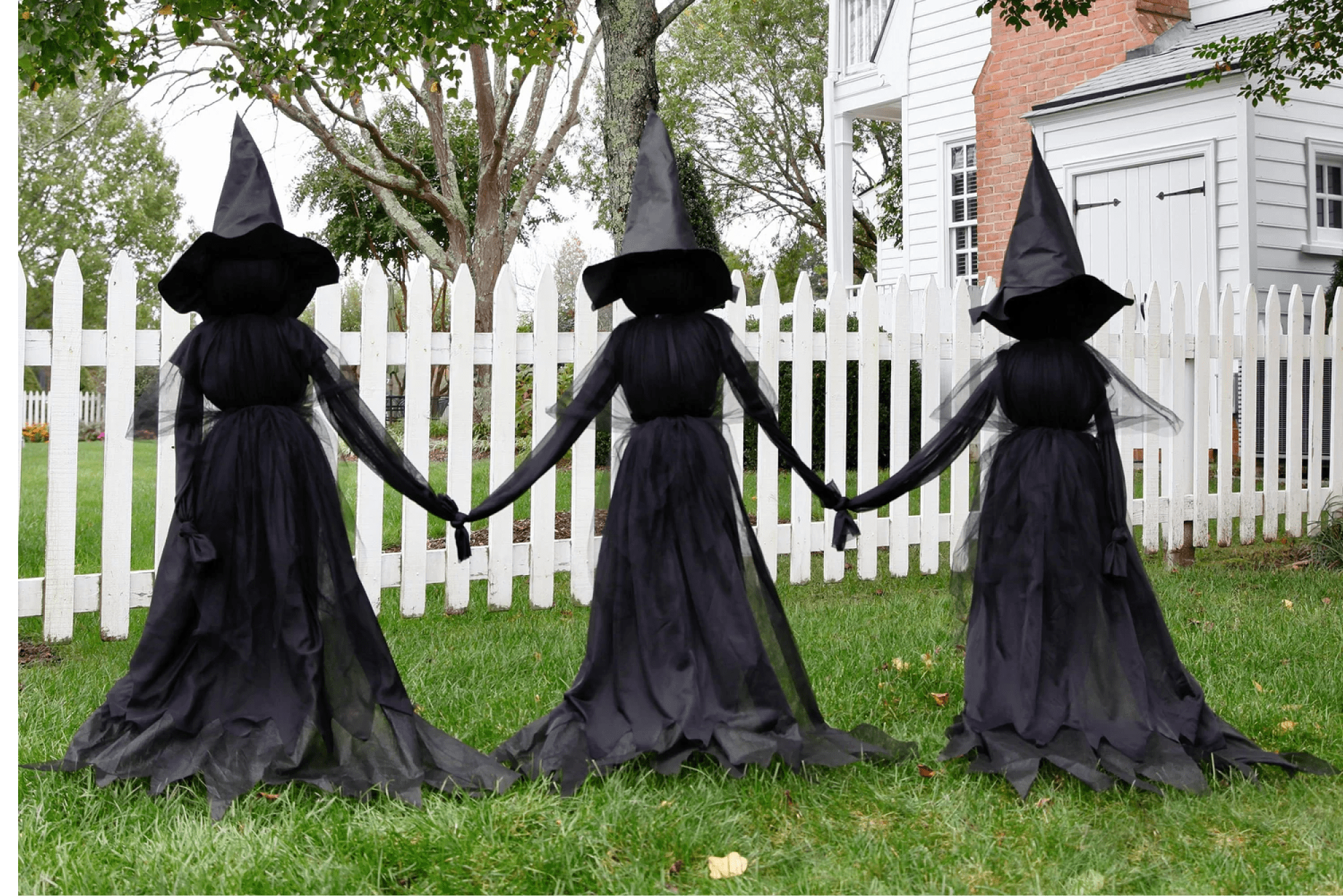 Trio of witches Halloween decor on a lawn 