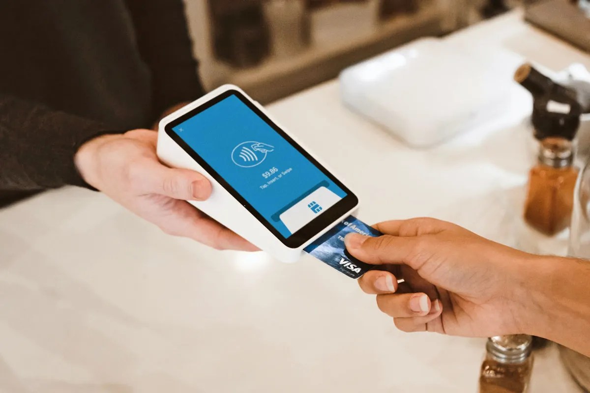 Someone placing their credit card in a card reader