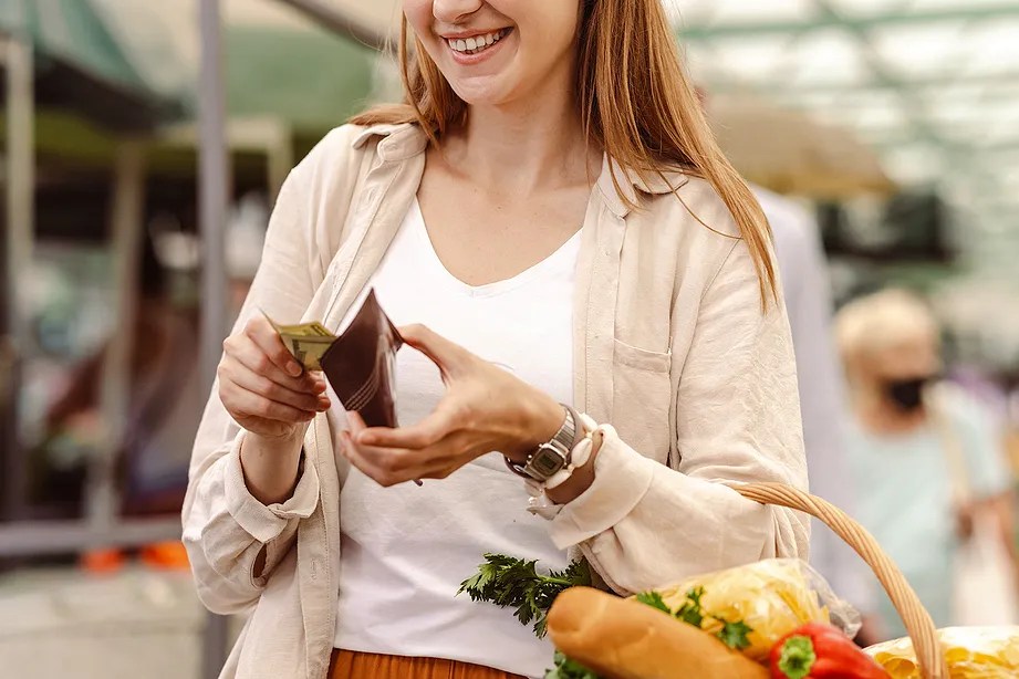Woman pulling cash out of her wallet. 