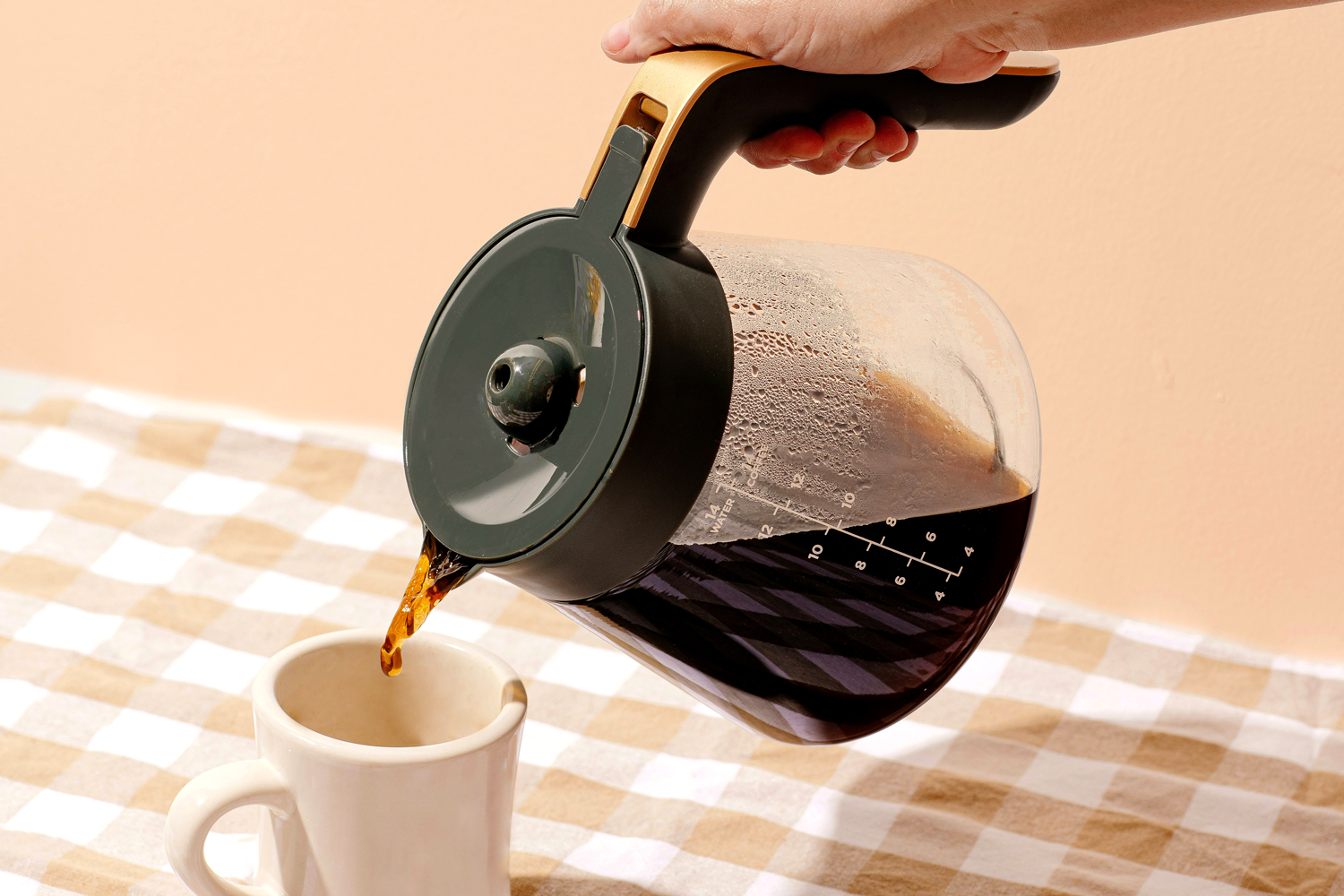 Person pouring coffee into a mug 